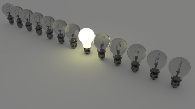 Como o rateio de custos de energia pode aumentar a eficiência, gerando economia energética. Na imagem: Fileira de lâmpadas elétricas, uma acesa, ao centro, e as demais apagadas (Foto: Colin Behrens/Pixabay)