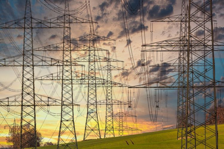 Investimento em eficiência precisa triplicar até 2030. Na imagem: Torres de transmissão de energia elétrica, com pôr do sol ao fundo e céu nas cores amarela e laranja (Foto: Pixabay)