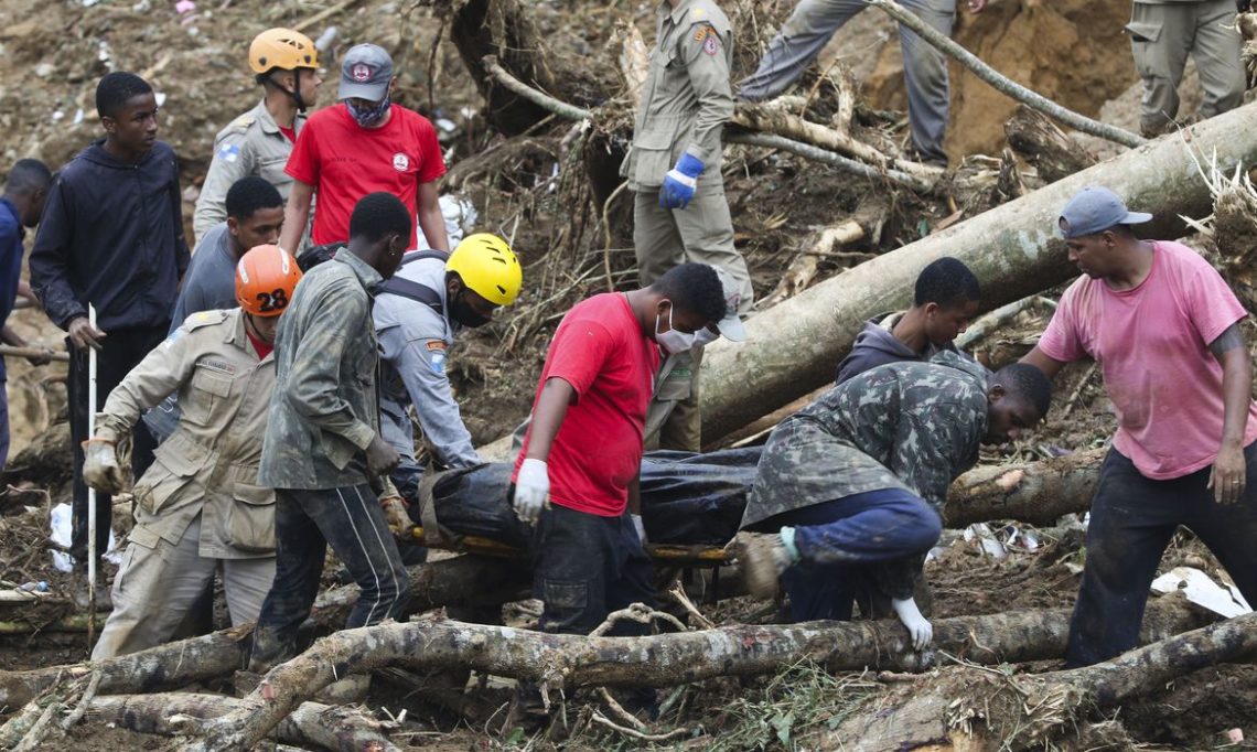 Bombeiros, moradores e voluntários trabalham no local do deslizamento no Morro da Oficina, após a chuva que assolou Petrópolis, na região serrana fluminense