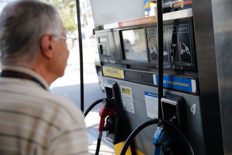 Preços da Petrobras: combustível mais caro limita aumento do consumo. Na imagem, Homem olhando visor de bomba de combustíveis (Foto: Fernando Frazão/Agência Brasil)