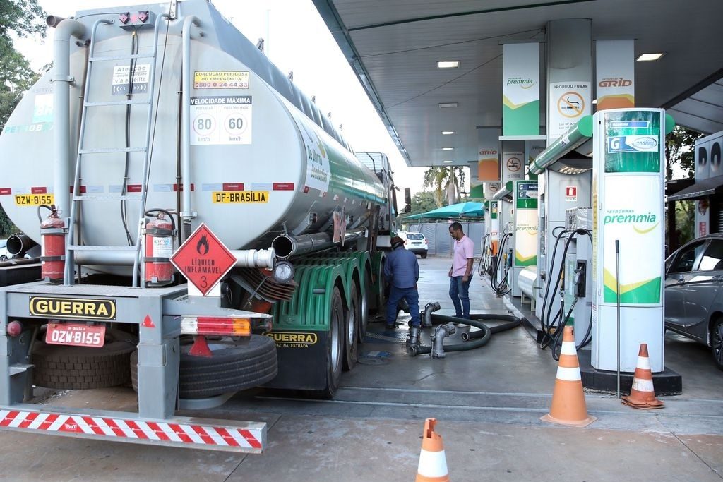 Trabalhador conecta mangueira a caminhão-tanque para abastecimento de posto de combustíveis da Petrobras (Foto: Marcello Casal Jr/Agência Brasil)