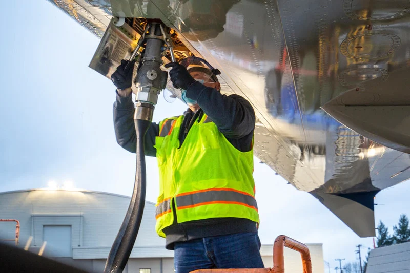 Descarbonização, mandatos e reservas no mercado de combustíveis. Na imagem, técnico de manutenção de aviação carrega combustível de aviação sustentável no Boeing ecoDemonstrator 2021 (Foto: Boeing/Divulgação)
