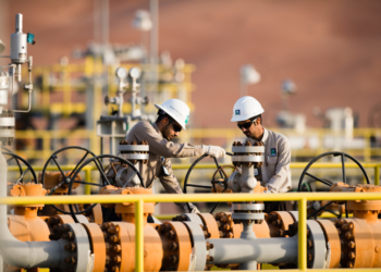 As repercussões do maior corte de produção da Opep desde 2020. Na imagem, dois trabalhadores operam instalações em gasoduto (Foto: Divulgação/Saudi Aramco)