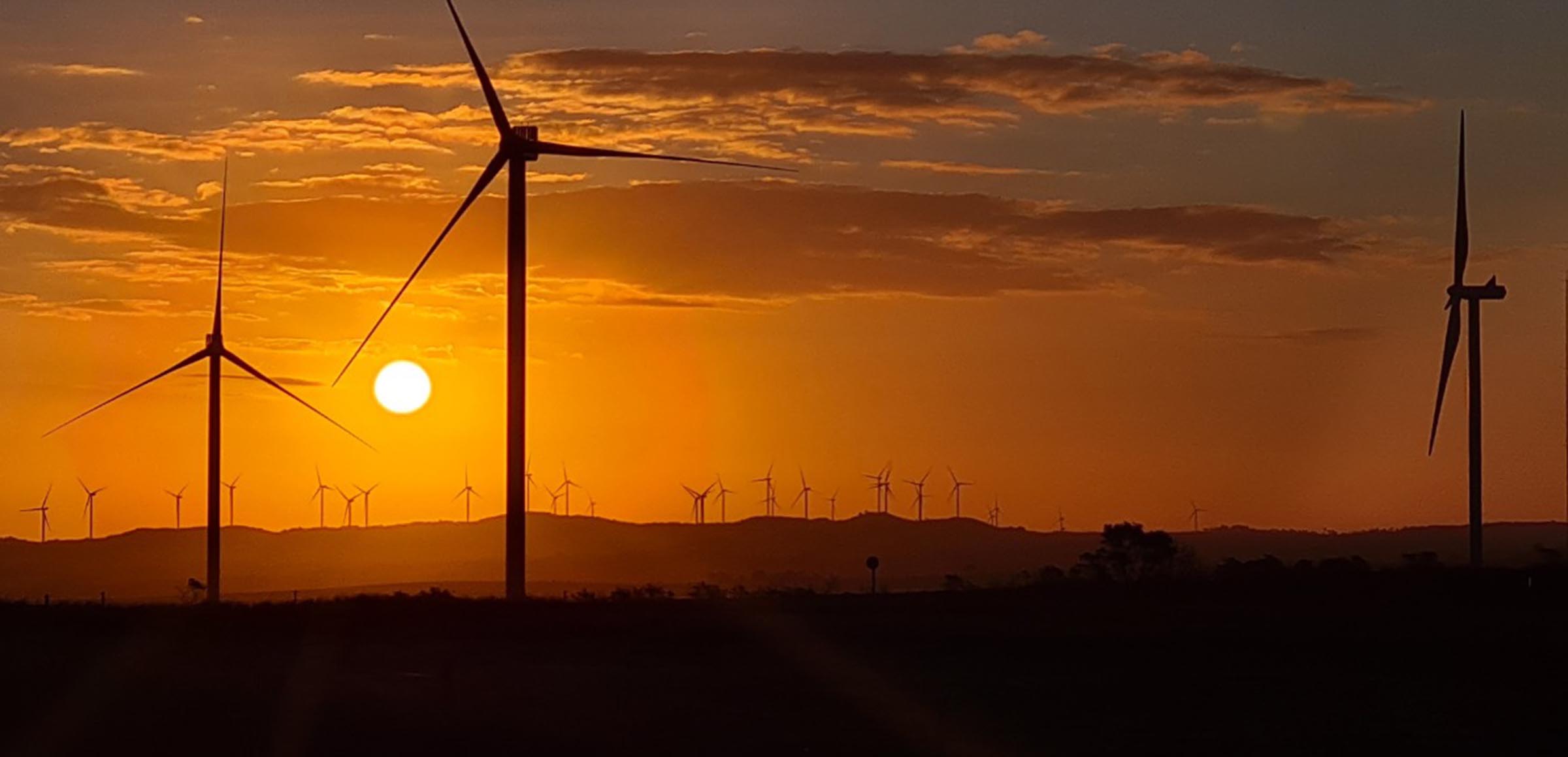 Transição energética e cooperação internacional: o que o Brasil pode aprender com a África do Sul. Na imagem: Turbinas eólicas da Enel Green Power no continente africano, com pôr-do-sol so fundo e céu em tom alaranjado (Foto: Divulgação RES4Africa/Enel)