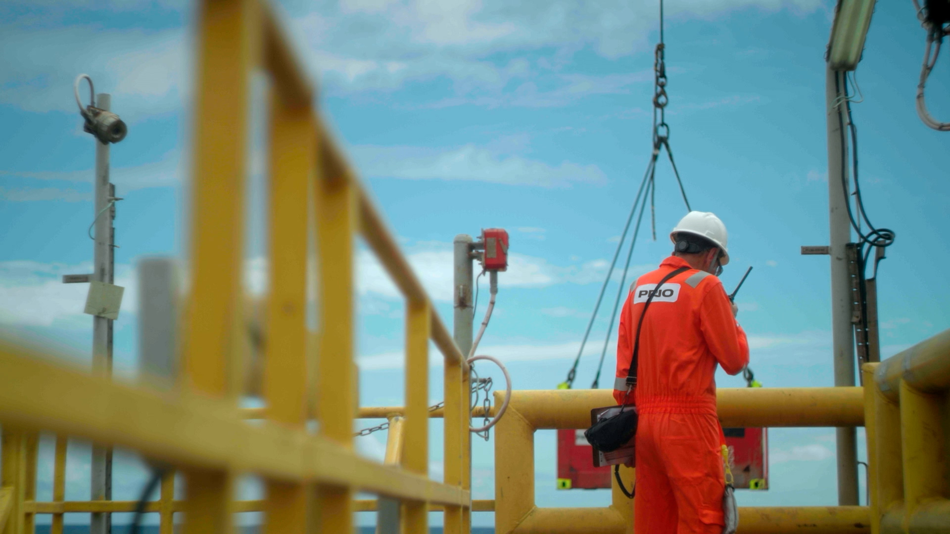 Os efeitos colaterais da taxação das exportações de petróleo. Na imagem: Funcionário da PRIO de uniforme laranja e capacete branco, de costas, em plataforma na Bacia de Campos (Foto: Cortesia)