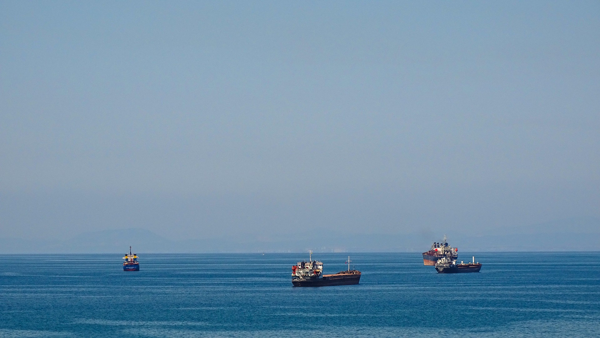 Combustíveis marítimos de baixo carbono ganham incentivo na Europa. Na imagem: Quatro navios de carga transitam no oceano azul (Foto: Pixabay)