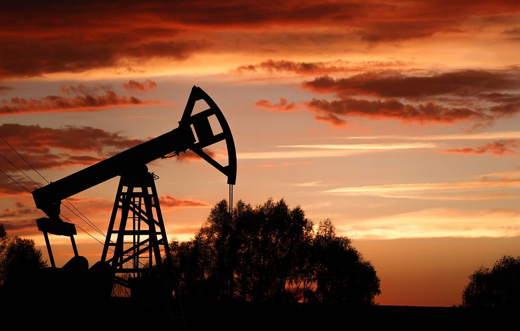Mercado de petróleo avalia efeitos da crise bancária. Na imagem: Cavalo-de-pau para produção de petróleo onshore na Rússia e, ao fundo, céu alaranjado (Foto: Yegor Aleyev/TASS)