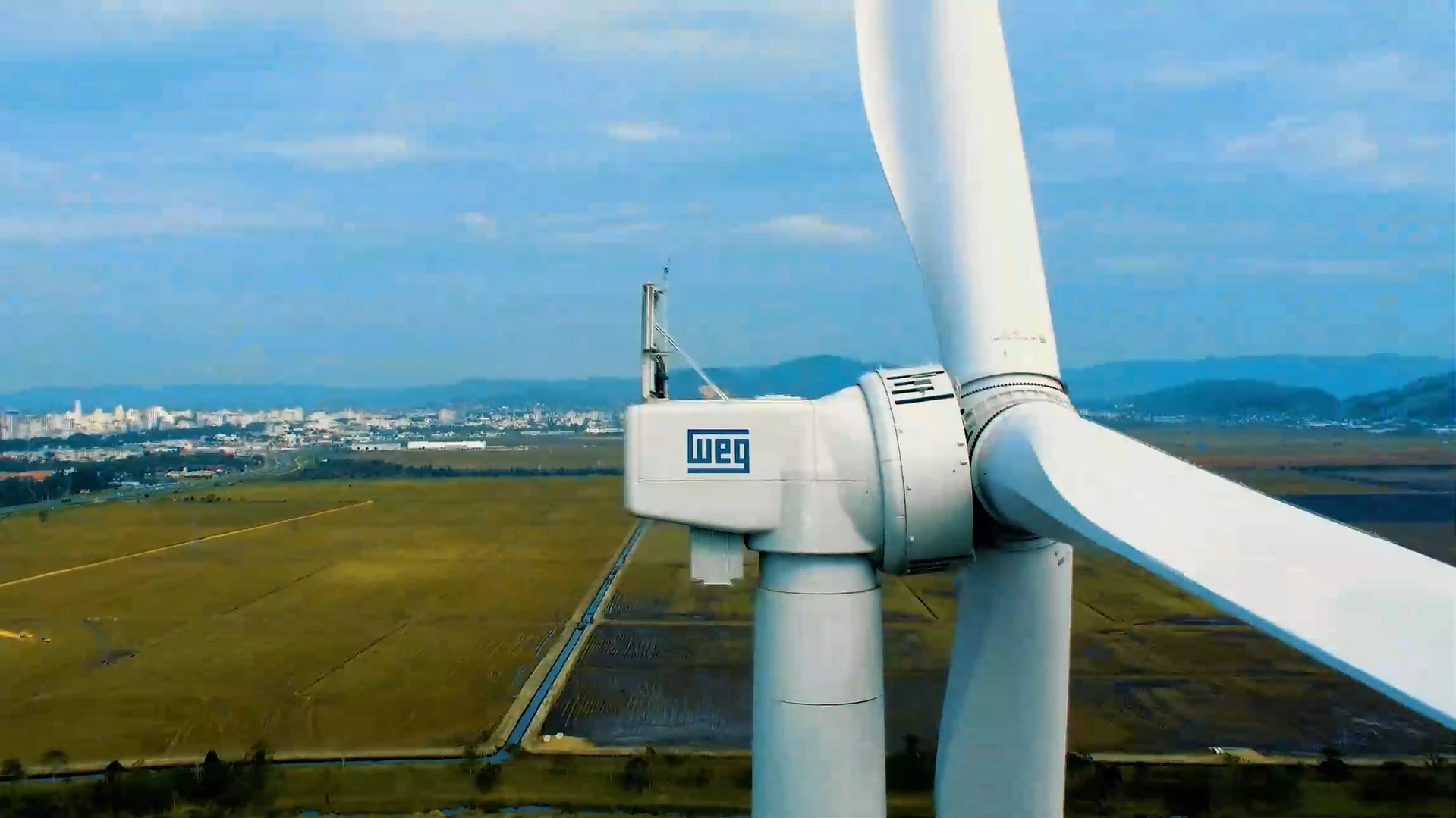 BNDES financia novo aerogerador da WEG. Na imagem: Parte de cima de aerogerador gigantesco da WEG com logomarca da empresa na lateral do compartimento da turbina (Foto: Divulgação)
