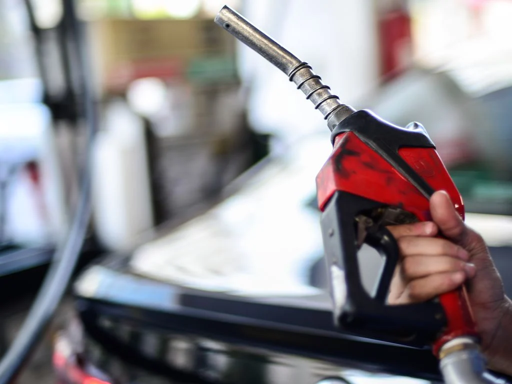 Volta de impostos federais sobre gasolina e etanol elevará em 4% o preço na bomba, diz Leggio Consultoria. Na imagem: Frentista segura bomba de abastecimento vermelha em posto de combustíveis (Foto: Marcello Casal Jr./Agência Brasil)