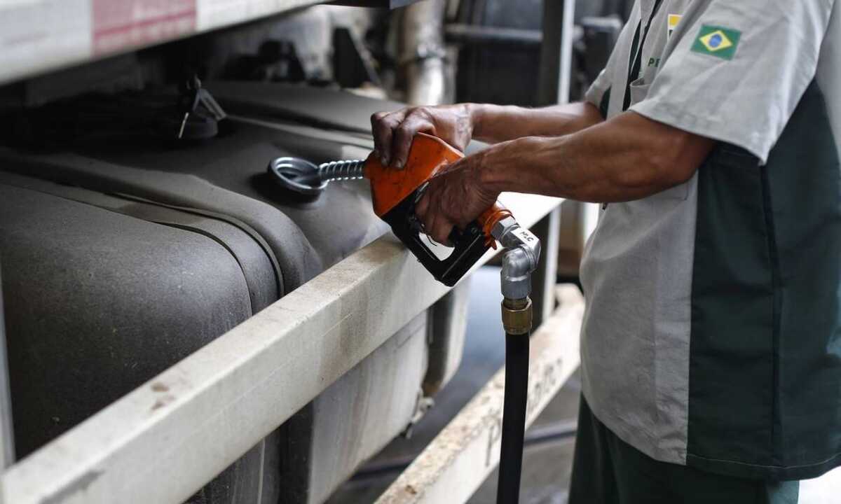 Imposto do diesel vai pagar desconto para veículos; entenda. Na imagem: Mão de frentista segura gatilho e abastece tanque de caminhão a diesel em posto da Petrobras (Foto: Divulgação Scania)