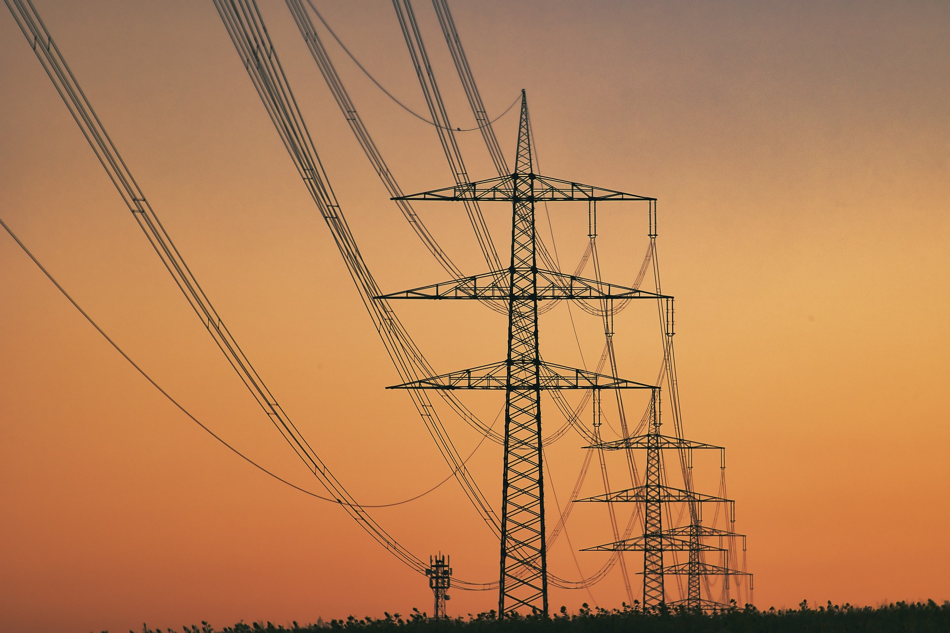 Leilão de transmissão de energia tem 7 vencedores e negocia todos os lotes. Na imagem: Linhas de transmissão de energia e, ao fundo, pôr do sol (Foto: Monikas Wunderwelt/Pixabay)