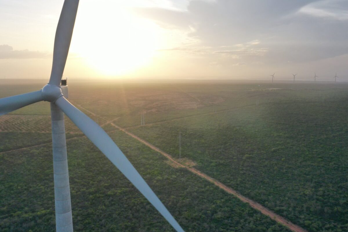 Foto em close de hélice de grande turbina eólica no parque eólico Maral, da Total Eren, no Rio Grande do Norte; com pôr do sol ao fundo (Foto: Divulgação)