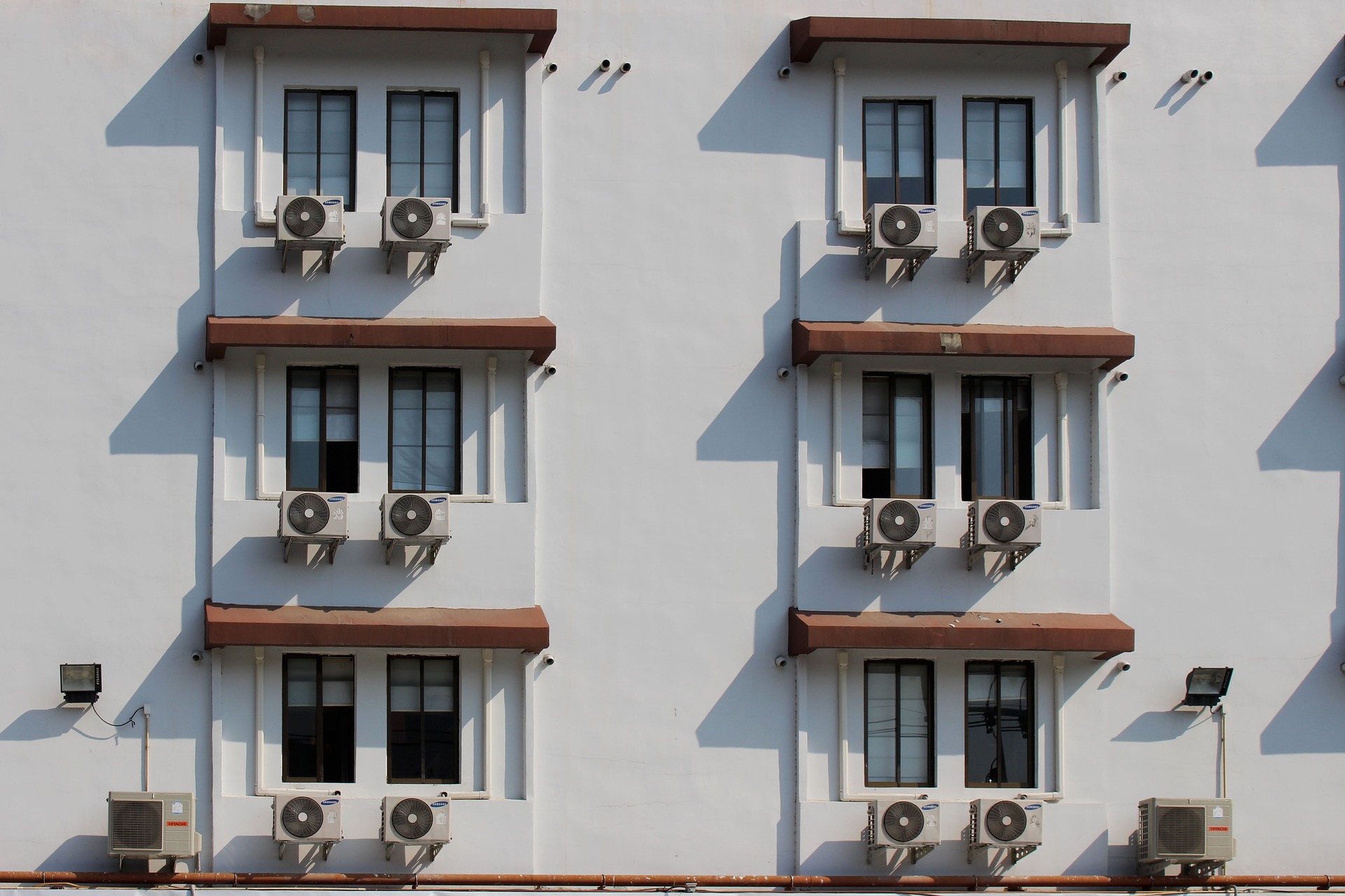 Governo federal promulga Emenda de Kigali; entenda o que isso significa. Na imagem: Foto de edifício com seis janelas e ar-condicionado embaixo de cada uma delas (Foto: Pixabay)