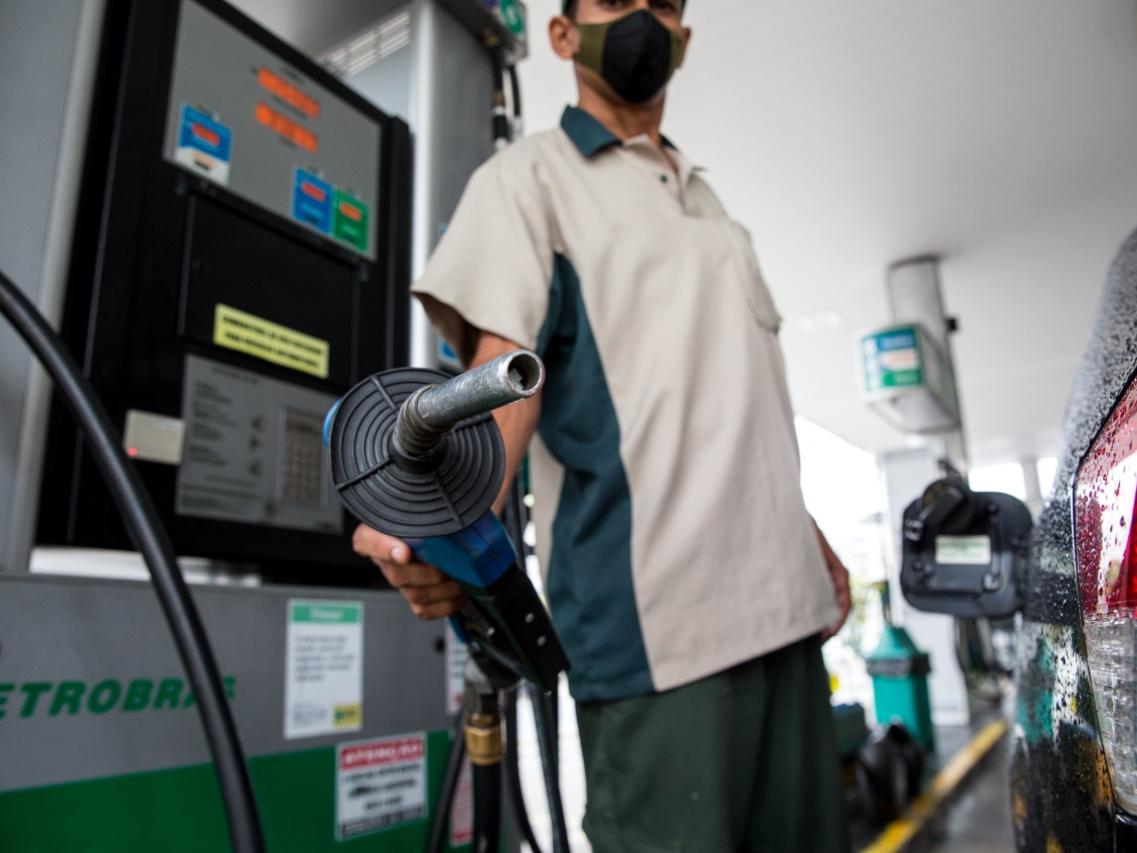 Petrobras vai aumentar em 16% o preço da gasolina e em 28% o do diesel. Na imagem: Frentista segura bomba de abastecimento em posto de combustíveis, apontando o bico para a câmera; ao lado, um veículo preto (Foto: Divulgação Petrobras)