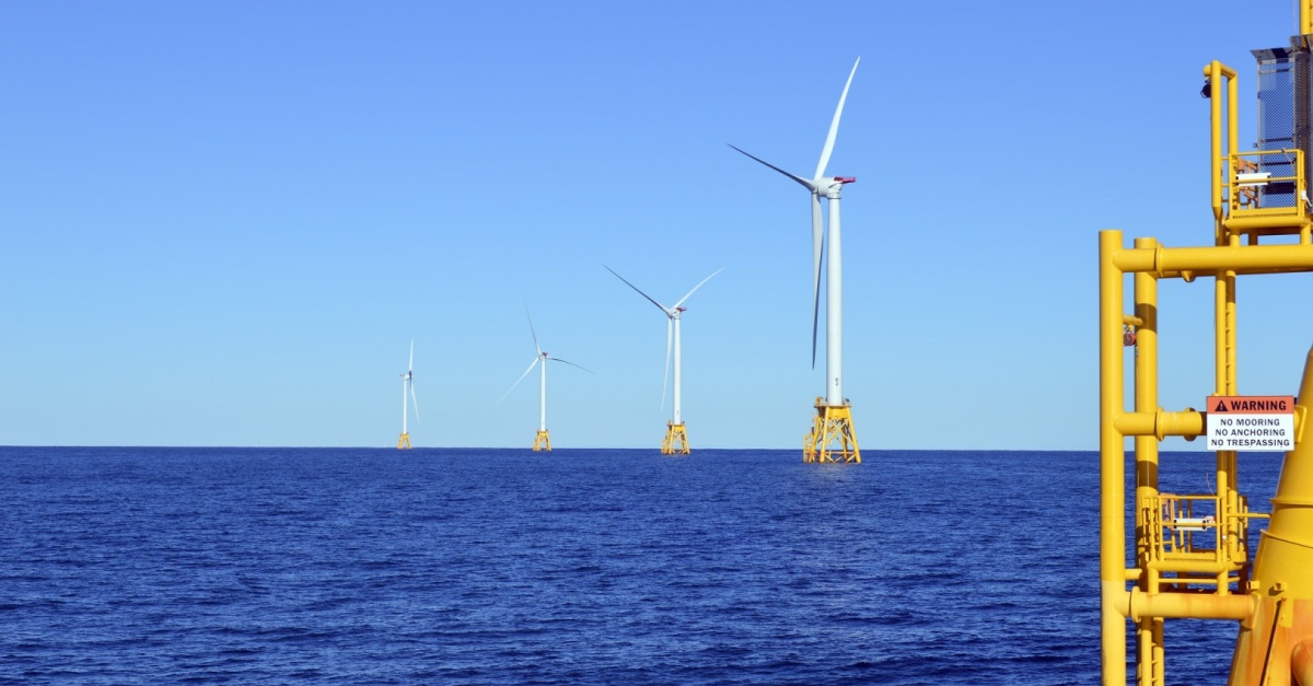 Usina eólica offshore na costa dos Estados Unidos; Turbinas brancas enfileiradas em mar azul escuro sob um céu azul claro (Foto: Divulgação Boem)