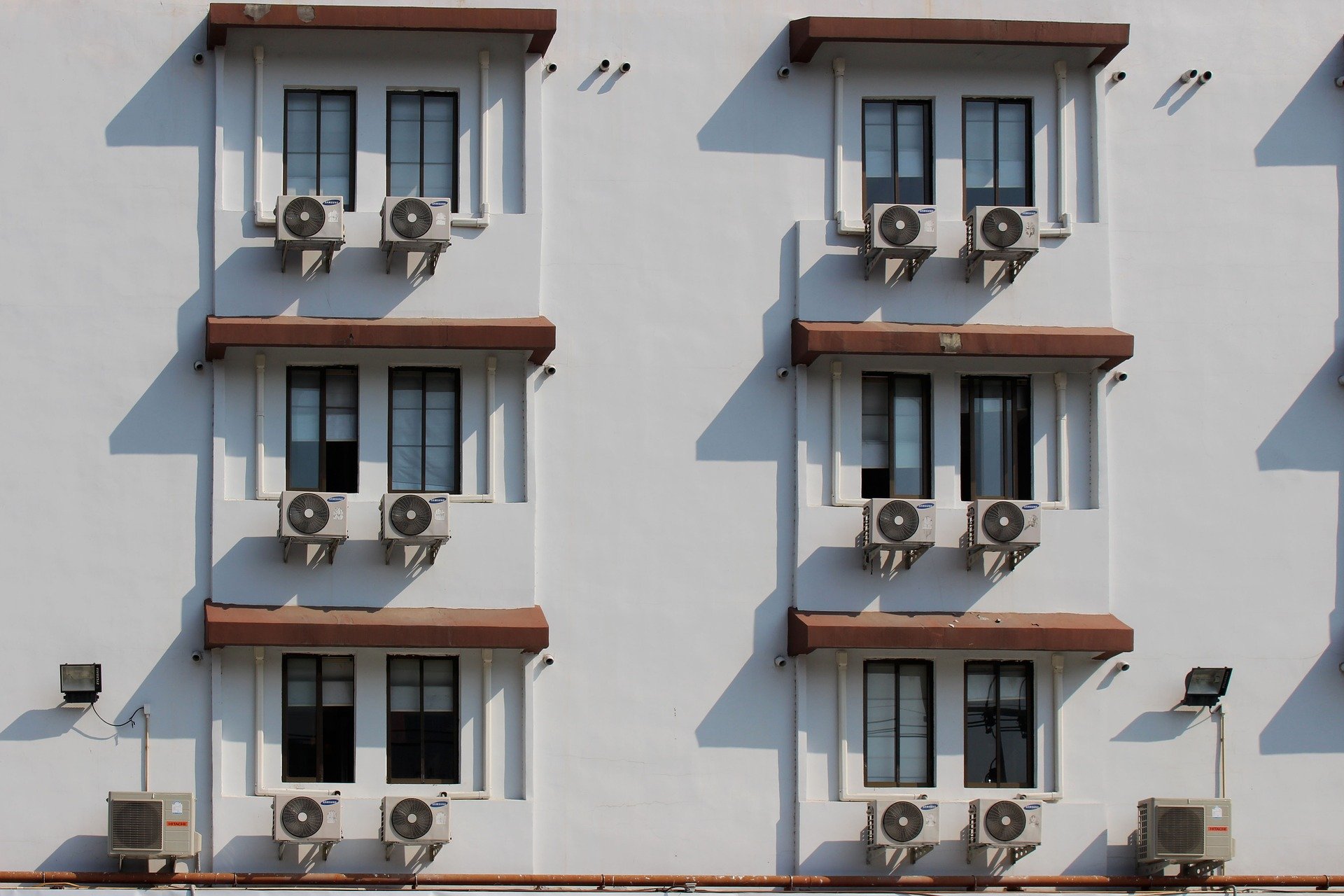A hora e a vez da eficiência energética na matriz brasileira. Na imagem: Foto de edifício com seis janelas e ar-condicionado embaixo de cada uma delas (Foto: Pixabay)