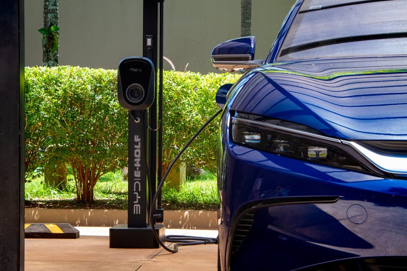 Por que o Brasil vai voltar com taxação para importar carros elétricos? Na imagem: Carro elétrico esportivo azul conectado a estação de recarga (Foto: Divulgação BYD)