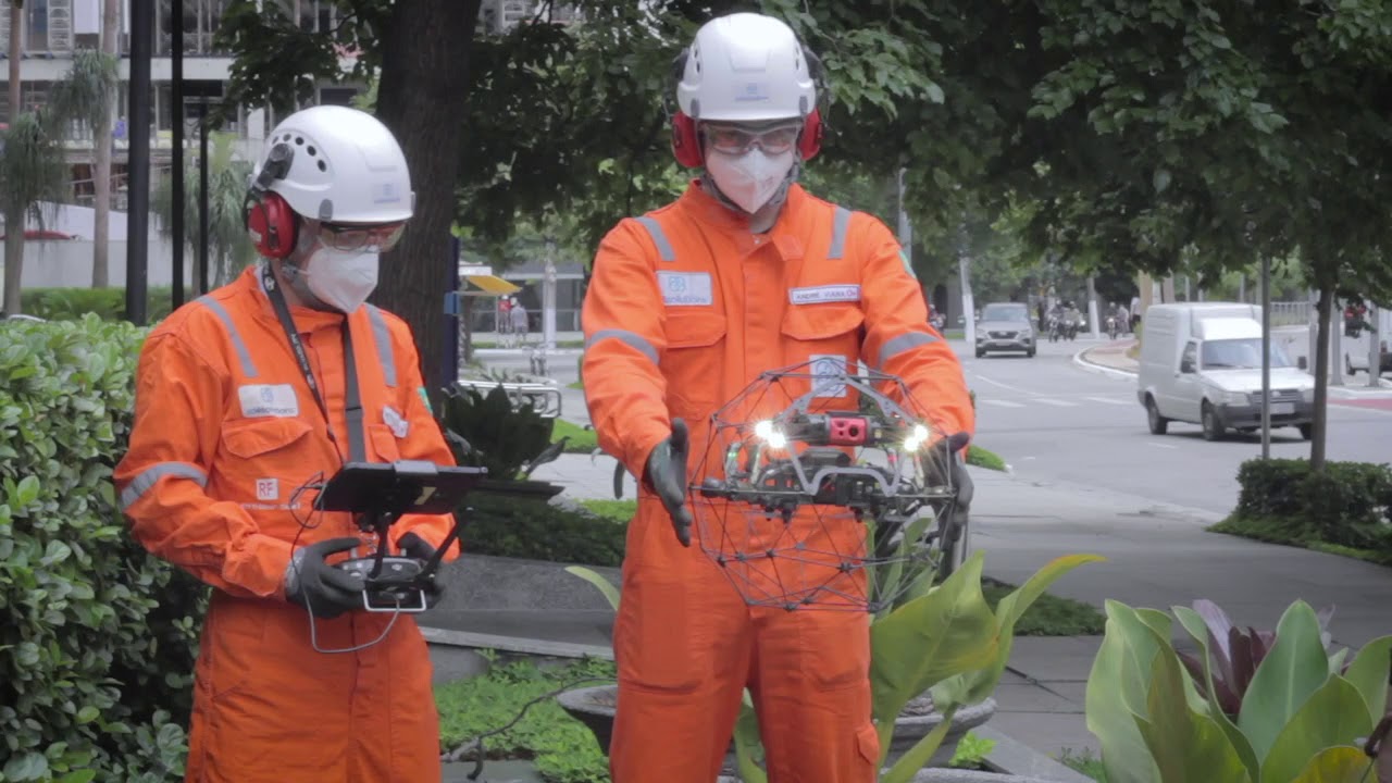 Por que é tão complexo substituir as redes de energia aéreas por linhas de transmissão subterrâneas no Brasil? Na imagem: Dois trabalhadores operam drones que monitoram e inspecionam câmaras subterrânea, no projeto Urban Futurability em São Paulo (Foto: Reprodução Enel)