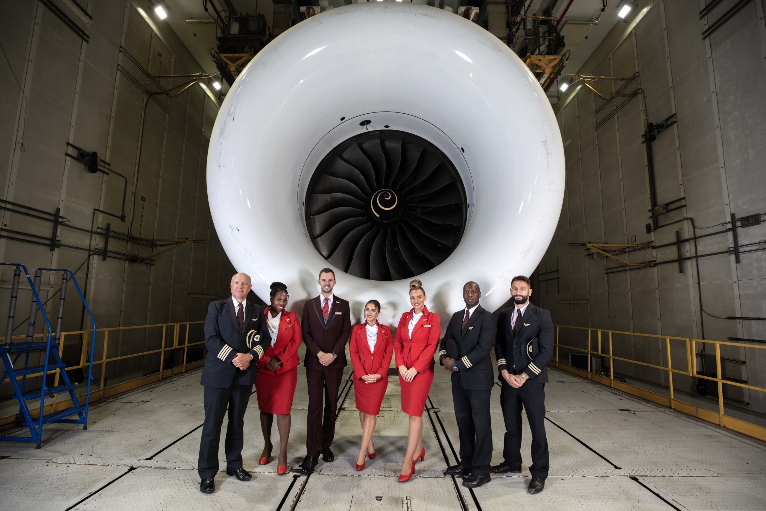 Tripulação em frente a turbina da aeronave Boeing 787, com motor Rolls-Royce Trent 1000, que fará o voo com 100% de SAF de Londres a Nova Iorque (Foto: Virgin Atlantic)