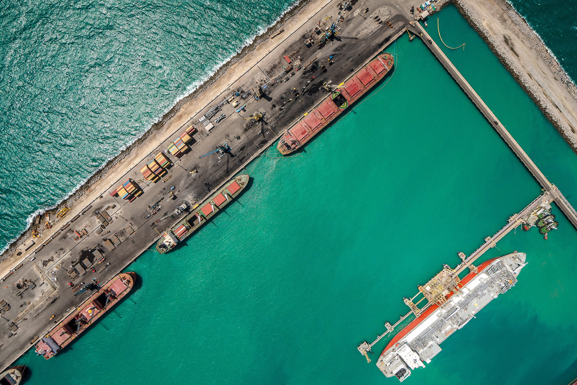 Ceará libera primeira licença ambiental a uma empresa de hidrogênio verde, a australiana Fortescue. Na imagem: Vista aérea vertical de embarcações atracadas no cais do Porto do Pecém, com água esverdeada ao redor (Foto: Divulgação)