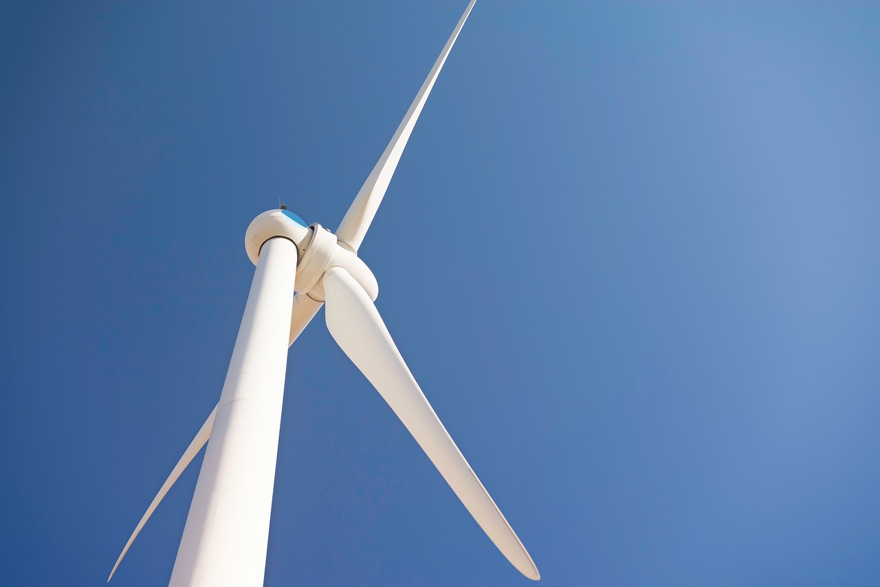 Triplicar energias renováveis no mundo até 2030 é difícil, mas realizável, aponta análise da BloombergNEF.. Na imagem: Turbina eólica branca vista de baixo para cima e, ao fundo, céu azul n(Foto: Pixabay)