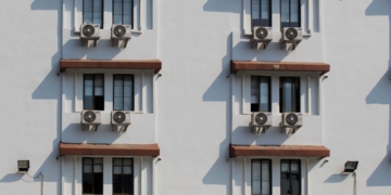 Governo Lula vai propor índice mínimo de eficiência energética a ser atendido por edificações em 2025. Na imagem: Foto de edifício com seis janelas e ar-condicionado embaixo de cada uma delas (Foto: Pixabay)